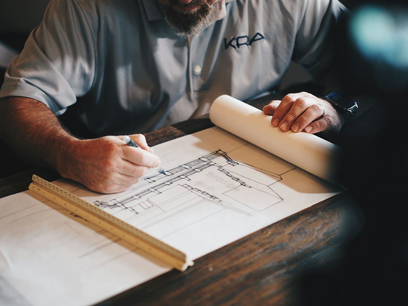 An architect working over a drawing at a drafting table